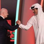 
              FIFA President Gianni Infantino, left, and Emir of Qatar Sheikh Tamim bin Hamad Al Thani shake hands before the 2022 soccer World Cup draw at the Doha Exhibition and Convention Center in Doha, Qatar, Friday, April 1, 2022. (AP Photo/Hassan Ammar)
            