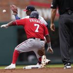 
              Washington Nationals' Maikel Franco (7) is safe at second base as Atlanta Braves' Ozzie Albies (1) fields the throw after a Braves' error during the first inning of a baseball game Wednesday, April 13, 2022, in Atlanta. (AP Photo/Brynn Anderson)
            