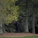 
              Scottie Scheffler hits out of the trees on the 18th hole during the second round at the Masters golf tournament on Friday, April 8, 2022, in Augusta, Ga. (AP Photo/Matt Slocum)
            