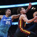 
              Atlanta Hawks guard Trae Young (11) drives to the basket past Charlotte Hornets forward P.J. Washington (25) during the first half of an NBA play-in basketball game Wednesday, April 13, 2022, in Atlanta. (AP Photo/John Bazemore)
            
