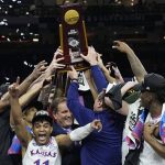 
              Kansas celebrates with the trophy after their win against North Carolina in a college basketball game at the finals of the Men's Final Four NCAA tournament, Monday, April 4, 2022, in New Orleans. (AP Photo/David J. Phillip)
            