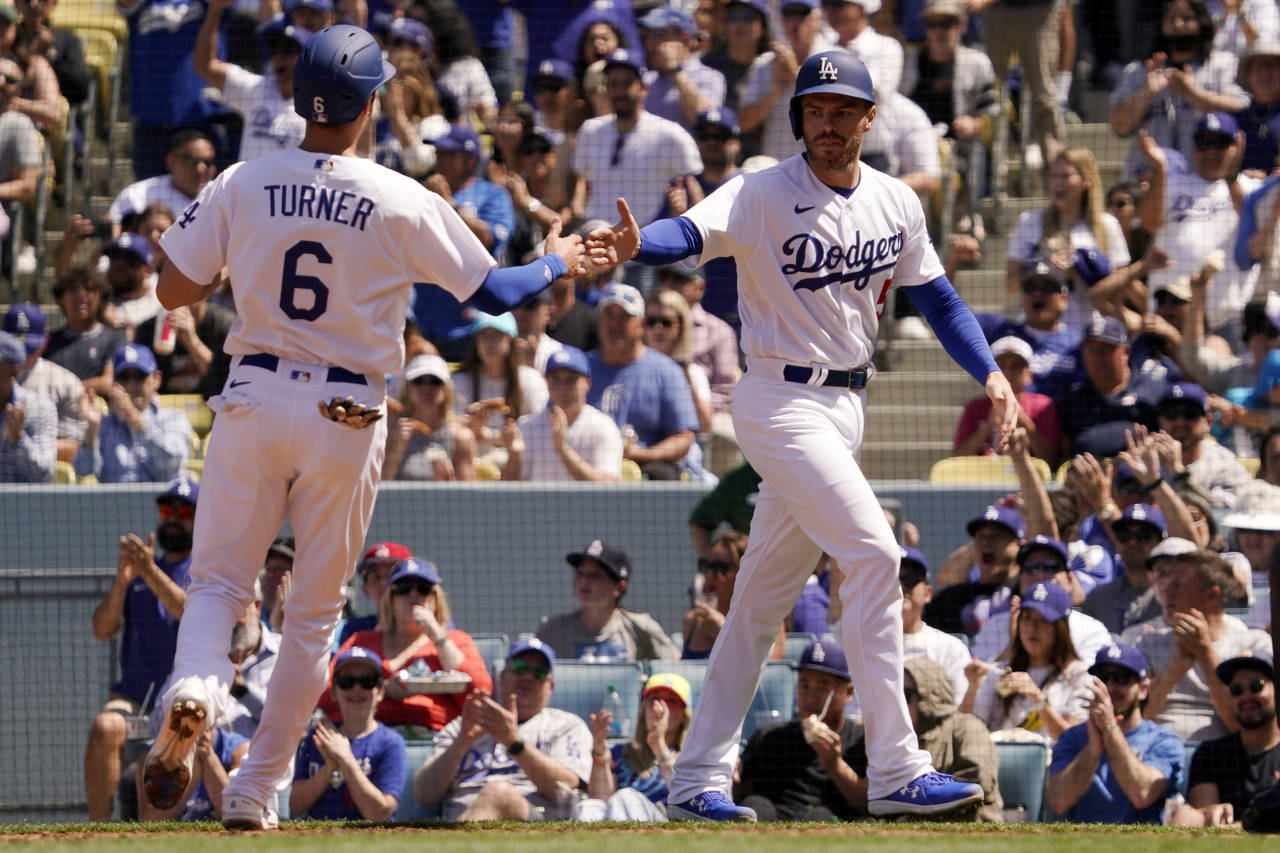 Los Angeles Dodgers' Trea Turner, left, and Freddie Freeman congratulate each other after they scor...