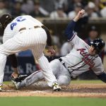 
              Atlanta Braves' Adam Duvall, right, scores before a tag by San Diego Padres relief pitcher Dinelson Lamet on a wild pitch during the eighth inning of a baseball game in San Diego, Friday, April 15, 2022. (AP Photo/Kyusung Gong)
            