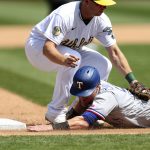 
              Texas Rangers' Kole Calhoun, bottom, is tagged out by Oakland Athletics third baseman Sheldon Neuse, top, on a ball hit by Rangers' Willie Calhoun during the fifth inning of a baseball game in Oakland, Calif., Saturday, April 23, 2022. (AP Photo/Jed Jacobsohn)
            