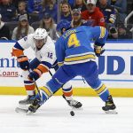 
              New York Islanders' Josh Bailey (12) and St. Louis Blues' Nick Leddy (4) vie for control of the puck during the first period of an NHL hockey game Saturday, April 9, 2022, in St. Louis. (AP Photo/Scott Kane)
            