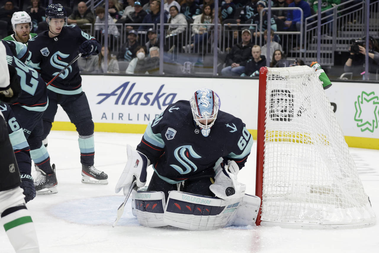 Seattle Kraken goaltender Chris Driedger (60) catches the puck on a shot by the Dallas Stars during...