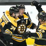 
              Boston Bruins left wing Brad Marchand, center, is congratulated by Jake DeBrusk (74) and Patrice Bergeron (37) after his empty-net goal against the Florida Panthers during the third period of an NHL hockey game, Tuesday, April 26, 2022, in Boston. (AP Photo/Charles Krupa)
            