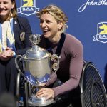 
              Manuela Schar, of Switzerland, smiles as she holds the trophy after winning the women's wheelchair division of the 126th Boston Marathon, Monday, April 18, 2022, in Boston. (AP Photo/Winslow Townson)
            
