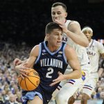 
              Villanova's Collin Gillespie (2) drives to the basket past Kansas forward Mitch Lightfoot during the first half of a college basketball game in the semifinal round of the Men's Final Four NCAA tournament, Saturday, April 2, 2022, in New Orleans. (AP Photo/David J. Phillip)
            
