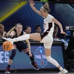 
              UConn's Paige Bueckers passes arpound Stanford's Lexie Hull during the second half of a college basketball game in the semifinal round of the Women's Final Four NCAA tournament Friday, April 1, 2022, in Minneapolis. UConn won 63-58 to advance to the finals. (AP Photo/Charlie Neibergall)
            