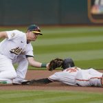 
              Oakland Athletics' Sheldon Neuse, left, tags out Baltimore Orioles' Cedric Mullins trying to steal second base during the first inning of a baseball game in Oakland, Calif., Wednesday, April 20, 2022. (AP Photo/Jeff Chiu)
            