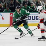 
              Dallas Stars center Tyler Seguin (91) moves the puck up the ice against New Jersey Devils center Nico Hischier (13) during the first period of an NHL hockey game in Dallas, Saturday, April 9, 2022. (AP Photo/Michael Ainsworth)
            