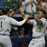 
              Oakland Athletics center fielder Cristian Pache (20) celebrates with teammates Kevin Smith (1) and Elvis Andrus (17) after hitting a three-run RBI during the second inning of a baseball game against the Tampa Bay Rays, Thursday, April, 14, 2022, in St. Petersburg, Fla. (AP Photo/Scott Audette)
            