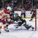 
              Calgary Flames left wing Johnny Gaudreau (13) flips the puck over Minnesota Wild goalie Cam Talbot (33) to score a goal during the second period of an NHL hockey game Thursday, April 28, 2022, in St. Paul, Minn. (AP Photo/Craig Lassig)
            