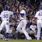 
              Los Angeles Dodgers' Freddie Freeman, center, is congratulated by Mookie Betts, left, and Edwin Rios after they scored on a double by Trea Turner during the fourth inning of a baseball game against the Atlanta Braves Monday, April 18, 2022, in Los Angeles. (AP Photo/Mark J. Terrill)
            