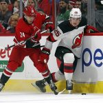 
              Carolina Hurricanes' Seth Jarvis (24) battles for the puck with New Jersey Devils' Nolan Foote (25) during the first period of an NHL hockey game in Raleigh, N.C., Thursday, April 28, 2022. (AP Photo/Karl B DeBlaker)
            