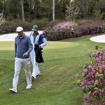 
              Scottie Scheffler walks to the 14th tee with his caddie, Ted Scott, during the third round of the Masters golf tournament at Augusta National on Saturday, April 9, 2022, in Augusta, Ga. (Hyosub Shin/Atlanta Journal-Constitution via AP)
            