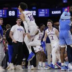 
              North Carolina guard Caleb Love, right, reacts to a loss as Kansas' Jalen Wilson (10) celebrates after a college basketball game in the finals of the Men's Final Four NCAA tournament, Monday, April 4, 2022, in New Orleans. Kansas won 72-69. (AP Photo/David J. Phillip)
            