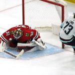 
              Chicago Blackhawks goaltender Kevin Lankinen, left, saves a shot by Seattle Kraken right wing Kole Lind during the third period of an NHL hockey game in Chicago, Thursday, April 7, 2022. The Kraken won 2-0. (AP Photo/Nam Y. Huh)
            