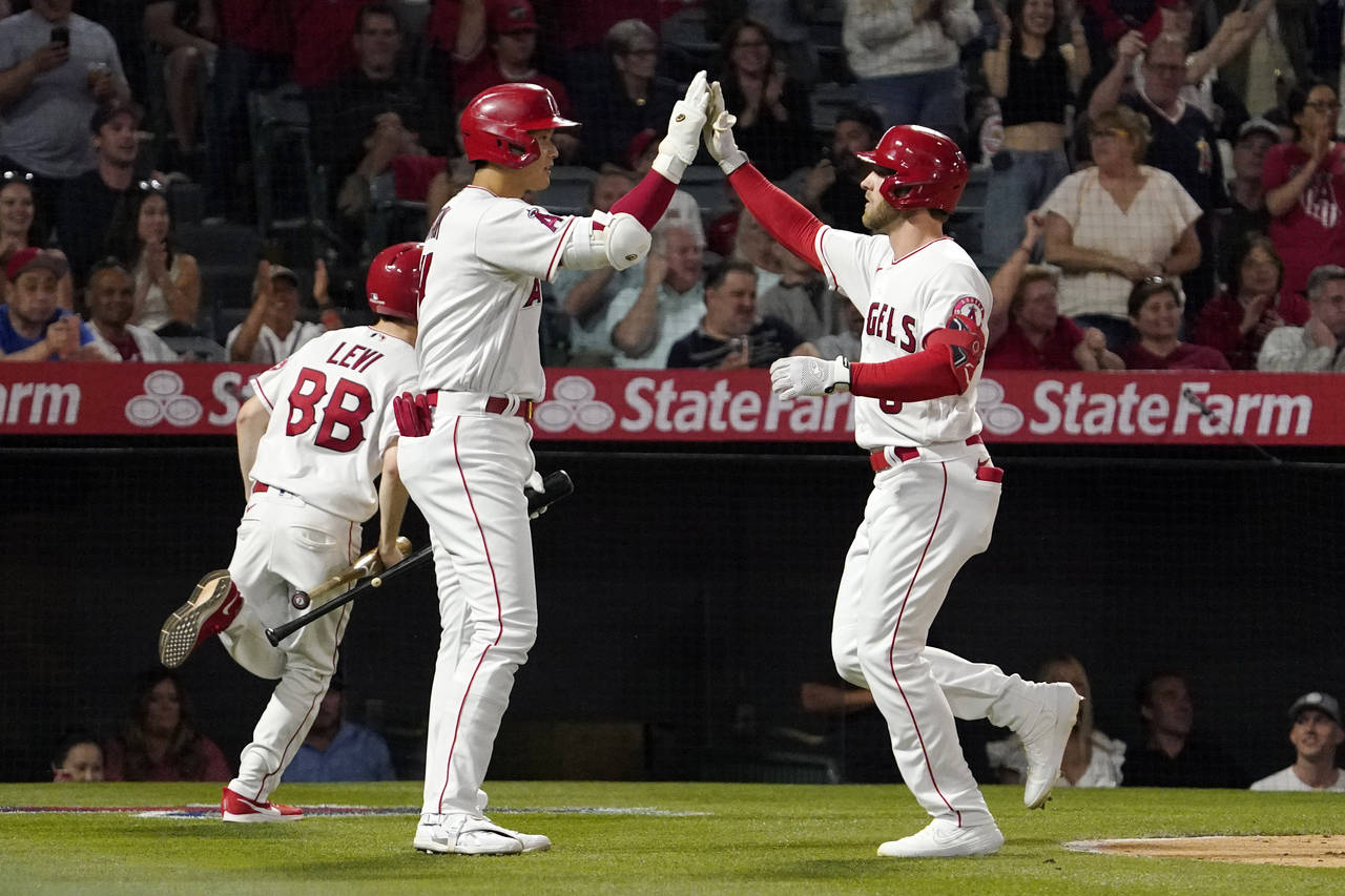 Los Angeles Angels' Taylor Ward, right, is congratulated by Shohei Ohtani after hitting a solo home...