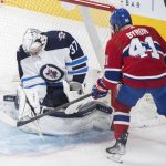 
              Winnipeg Jets goaltender Connor Hellebuyck makes a save against Montreal Canadiens' Paul Byron during the second period of an NHL hockey game, in Montreal, Monday, April 11, 2022. (Graham Hughes/The Canadian Press via AP)
            