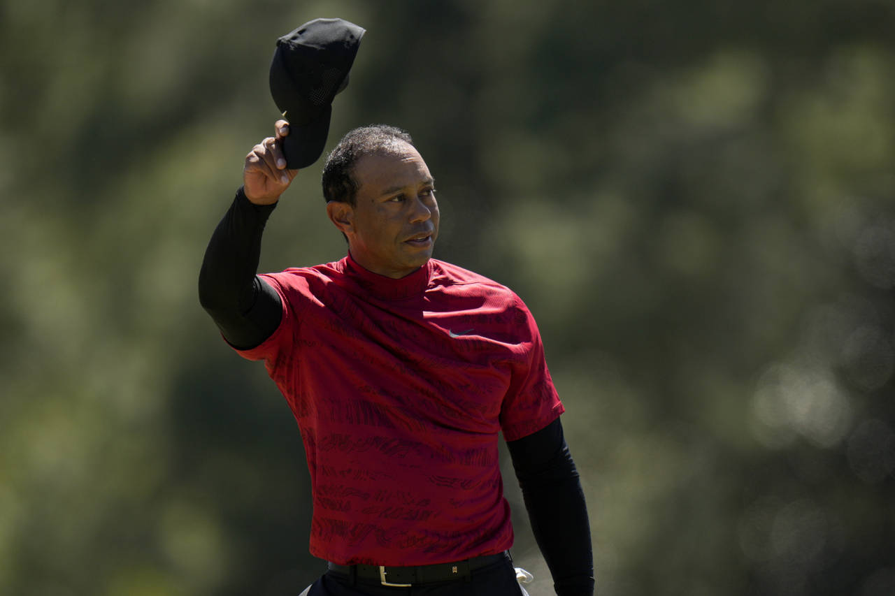 Tiger Woods tips his cap on the 18th green during the final round at the Masters golf tournament on...
