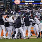 
              Detroit Tigers surround Javier Baez he hit a walk-off single during the ninth inning of a baseball game against the Chicago White Sox, Friday, April 8, 2022, in Detroit. (AP Photo/Carlos Osorio)
            