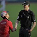 
              Kristi Moore, left, shakes hands with third base umpire Nic Lentz before a baseball game between the Miami Marlins and the Atlanta Braves on Friday, April 22, 2022, in Atlanta. Moore was punched in the face less than two weeks ago by a parent who did not agree with her call on a play at second base at a girls' softball game in Mississippi. Major League Baseball umpires Lance Barksdale and Ted Barrett were outraged when they heard of the assault on Moore. They wanted to show their support, so they invited her to Friday's game, which they are calling. (AP Photo/Ben Margot)
            