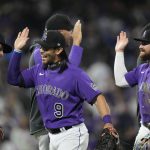 
              Teammates congratulate Colorado Rockies first baseman Connor Joe (9) and second baseman Brendan Rodgers (7) after the ninth inning of a baseball game against the Los Angeles Dodgers Saturday, April 9, 2022, in Denver. (AP Photo/David Zalubowski)
            