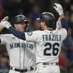Seattle Mariners' Ty France, left, is greeted by Adam Frazier (26) after France hit a two-run home run to score Frazier during the first inning of the team's baseball game against the Texas Rangers, Thursday, April 21, 2022, in Seattle. (AP Photo/Ted S. Warren)