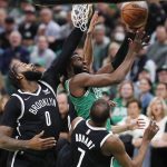 
              Boston Celtics' Jaylen Brown, top right, shoots against Brooklyn Nets' Andre Drummond (0) and Kevin Durant (7) during the first half of Game 2 of an NBA basketball first-round Eastern Conference playoff series Wednesday, April 20, 2022, in Boston. (AP Photo/Michael Dwyer)
            