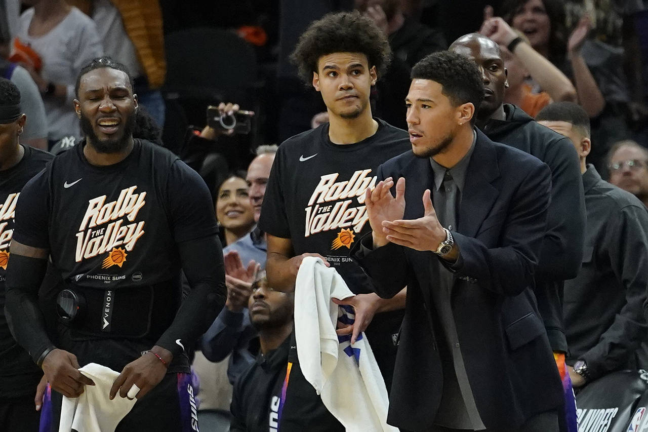 Phoenix Suns guard Devin Booker watches from the bench during the first half of Game 5 of an NBA ba...