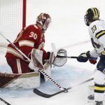 
              Michigan's Jimmy Lambert (23) scores on Denver's Magnus Chrona (30) during the second period of an NCAA men's Frozen Four semifinal hockey game, Thursday, April 7, 2022, in Boston. (AP Photo/Michael Dwyer)
            