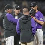 
              Colorado Rockies starting pitcher Chad Kuhl, right, confers with trainer Heath Townsend, second from right, home plate umpire Pat Hoberg, second from left, and manager Bud Black, left, as Kuhl is pulled from the mound before facing a Philadelphia Phillies batter in the seventh inning of a baseball game Monday, April 18, 2022, in Denver. (AP Photo/David Zalubowski)
            