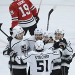 
              Los Angeles Kings' Trevor Moore (12) celebrates with Viktor Arvidsson (33), Sean Curzi (50), Troy Stecher (51) and Phillip Danault (24) after scoring a goal against the Chicago Blackhawks during the first period of an NHL hockey game Tuesday, April 12, 2022, in Chicago. (AP Photo/Paul Beaty)
            
