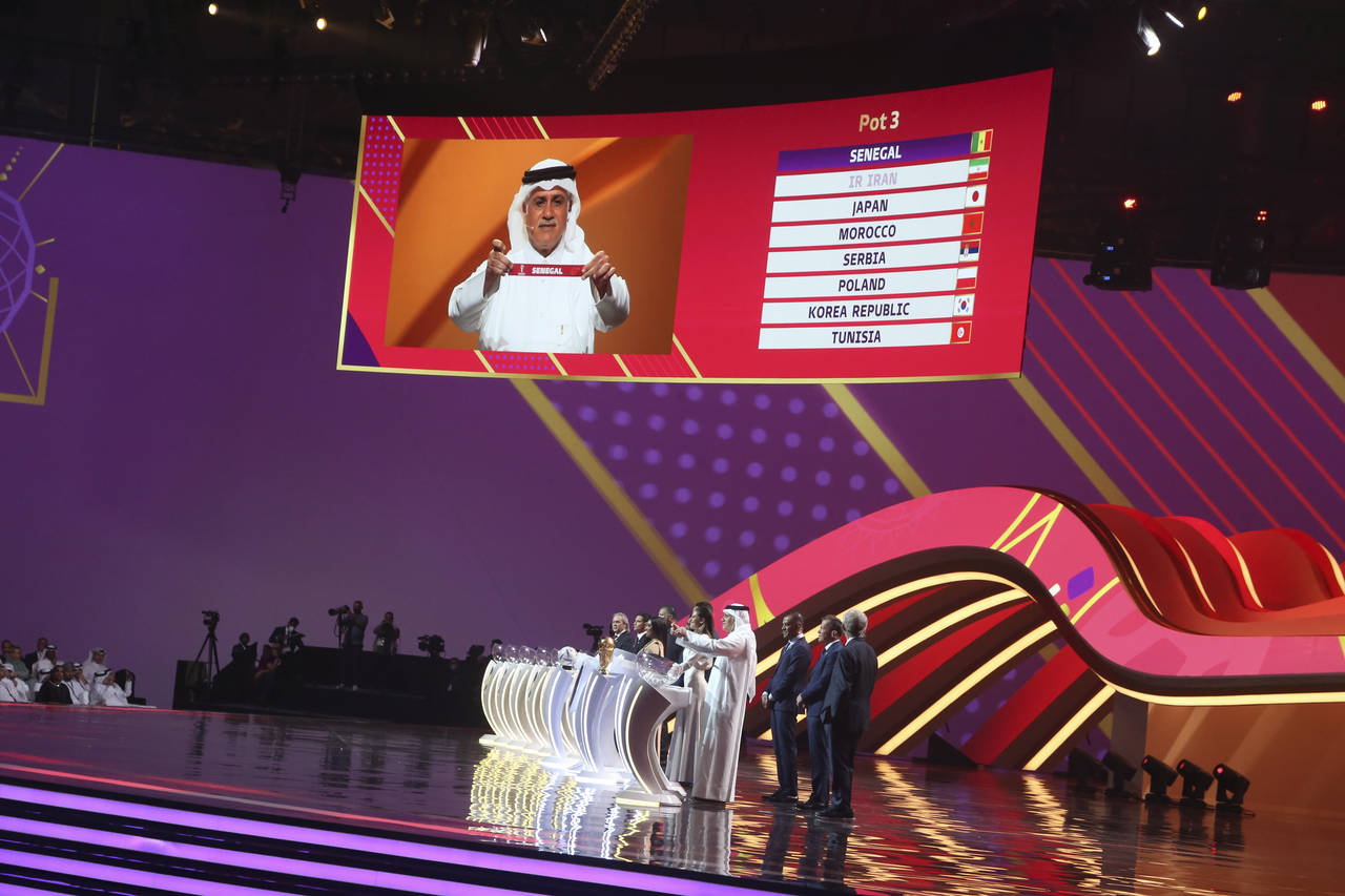 Former Qatari soccer international Adel Ahmed MalAllah holds up the name of Senegal the 2022 soccer...
