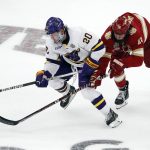
              Denver's Cameron Wright, right, and Minnesota State's Connor Gregga (20) compete for the puck during the second period of the NCAA men's Frozen Four championship college hockey game Saturday, April 9, 2022, in Boston. (AP Photo/Michael Dwyer)
            
