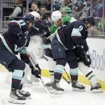 
              Seattle Kraken center Alex Wennberg (21) and center Ryan Donato (9) vie for the puck with Dallas Stars center Joe Pavelski behind the goal during the first period of an NHL hockey game Sunday, April 3, 2022, in Seattle. (AP Photo/John Froschauer)
            