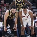 
              Toronto Raptors guard Fred VanVleet, left, jokes with a former teammate, Miami Heat guard Kyle Lowry, as Raptors forward Pascal Siakam (43) stands behind them during the first half of an NBA basketball game Sunday, April 3, 2022, in Toronto. (Nathan Denette/The Canadian Press via AP)
            
