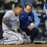 
              Kansas City Royals' Salvador Perez grimaces next to a trainer after being hit by a pitch during the seventh inning of the team's baseball game against the Seattle Mariners, Saturday, April 23, 2022, in Seattle. (AP Photo/Stephen Brashear)
            