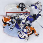 
              Players crash the net as Philadelphia Flyers' Noah Cates (49) pushes a loose puck into the net for a goal past Buffalo Sabres goaltender Dustin Tokarski during the second period of an NHL hockey game, Sunday, April 17, 2022, in Philadelphia. (AP Photo/Derik Hamilton)
            