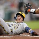 
              Milwaukee Brewers' Christian Yelich slides in ahead of the tag by Baltimore Orioles catcher Robinson Chirinos while scoring on a double by Andrew McCutchen during the first inning of a baseball game, Tuesday, April 12, 2022, in Baltimore. Brewers' Willy Adames also scored on the play. (AP Photo/Julio Cortez)
            