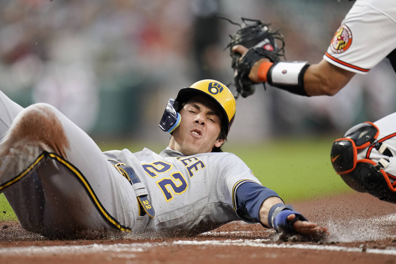 Milwaukee Brewers' Christian Yelich slides in ahead of the tag by Baltimore Orioles catcher Robinso...