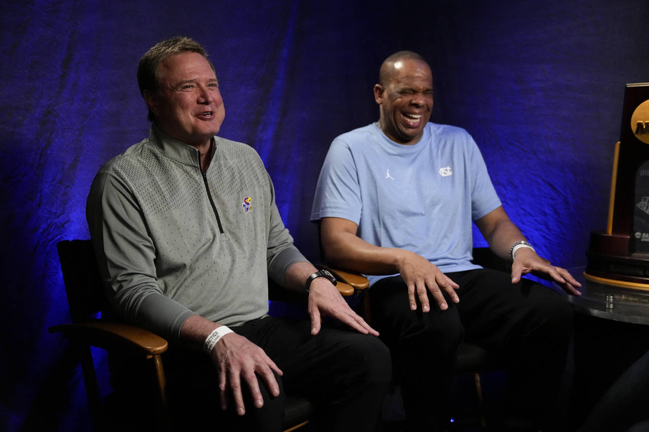 Kansas head coach Bill Self, left, and North Carolina head coach Hubert Davis talk during a CBS Spo...