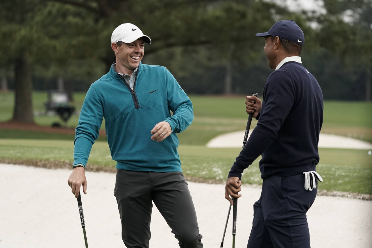 Tiger Woods is greeted by Rory McIlroy, of Northern Ireland during a practice round for the Masters...
