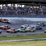 
              Bubba Wallace (23) hits the wall as Ross Chastain (1) leads the pack to the finish line during a NASCAR Cup Series auto race Sunday, April 24, 2022, in Talladega, Ala. (AP Photo/Butch Dill)
            
