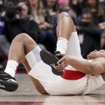 
              Toronto Raptors forward Scottie Barnes (4) grabs his injured ankle as he tumbles down during the first half of Game 4 of an NBA basketball first-round playoff series against the Philadelphia 76ers Saturday, April 23, 2022 in Toronto. (Nathan Denette/The Canadian Press via AP)
            