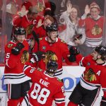 
              Chicago Blackhawks defenseman Alec Regula (75) celebrates with teammates after scoring against the Calgary Flames during the second period of an NHL hockey game, Monday, April 18, 2022, in Chicago. (AP Photo/Kamil Krzaczynski)
            