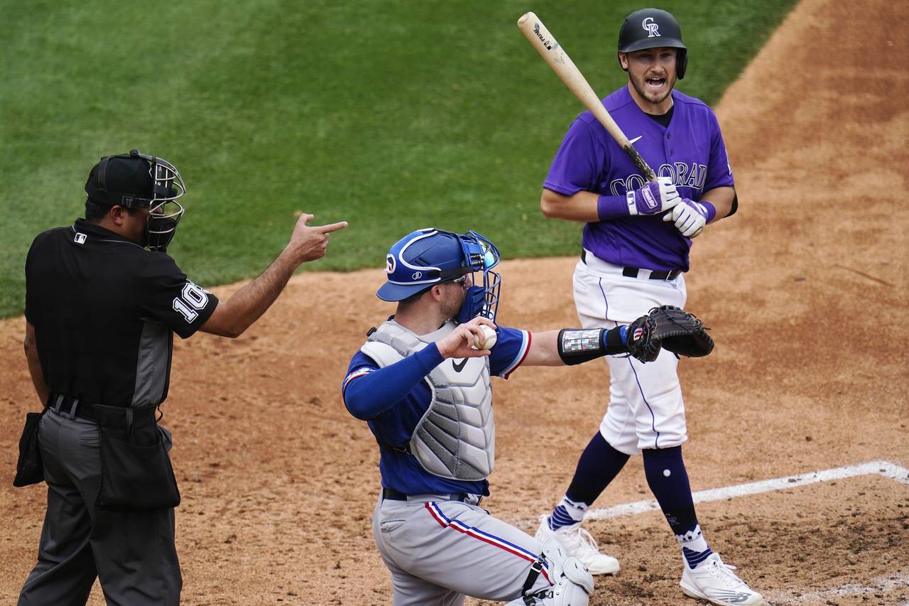 Colorado Rockies' Garrett Hampson, right, argues with umpire Nestor Ceja, left, after a called stri...