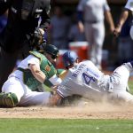 
              Texas Rangers' Eli White (41) slides safely into home plate as Oakland Athletics catcher Sean Murphy, front left, applies the tag on a ball hit by Rangers' Brad Miller during the eighth inning of a baseball game in Oakland, Calif., Saturday, April 23, 2022. (AP Photo/Jed Jacobsohn)
            